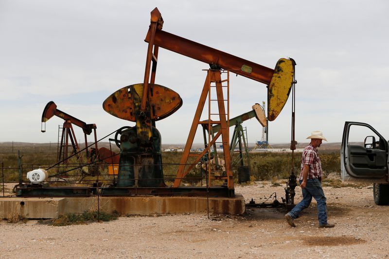 Paul Putnam, 53, a rancher and independent contract pumper walks past a pump jack in Loving County