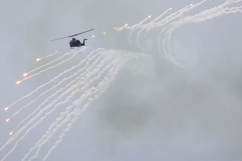 FILE PHOTO: An AH-1 Cobra helicopter fires during the live-fire, anti-landing Han Kuang military exercise, which simulates an enemy invasion, in Taichung