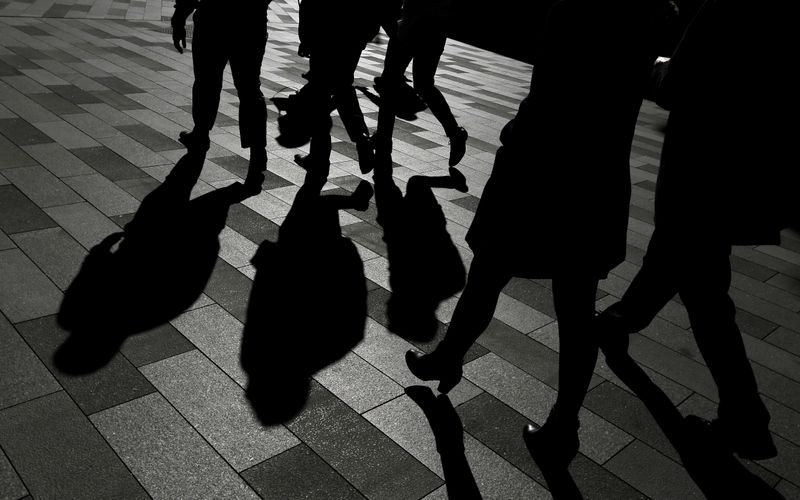 FILE PHOTO: Workers cast shadows as they stroll among the office towers Sydney's Barangaroo business district in Australia's largest city