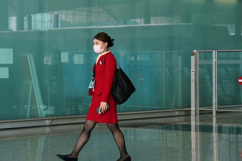 Cathay Pacific employee walks past the departures hall at Hong Kong International Airport in Hong Kong