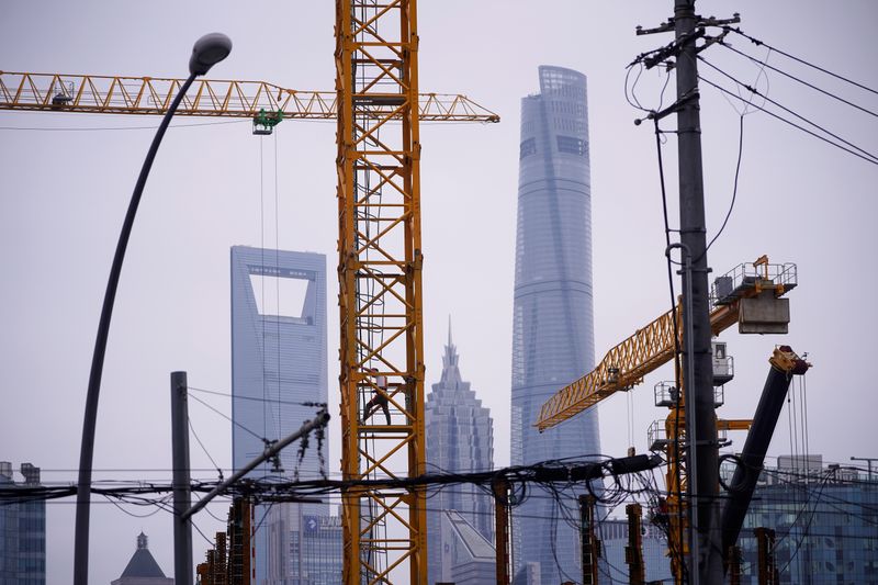 A worker is seen on a crane at a construction site in front of Lujiazui financial district, in Shanghai