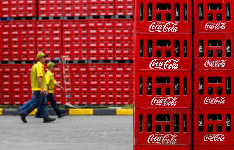 FILE PHOTO: Workers walk at PT Coca-Cola Amatil Indonesia's factory in Cibitung