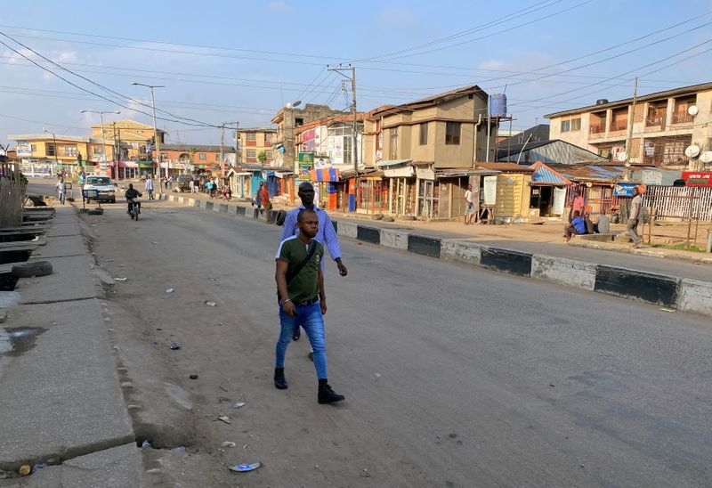 People walk along a street despite a round-the-clock curfew in Lagos