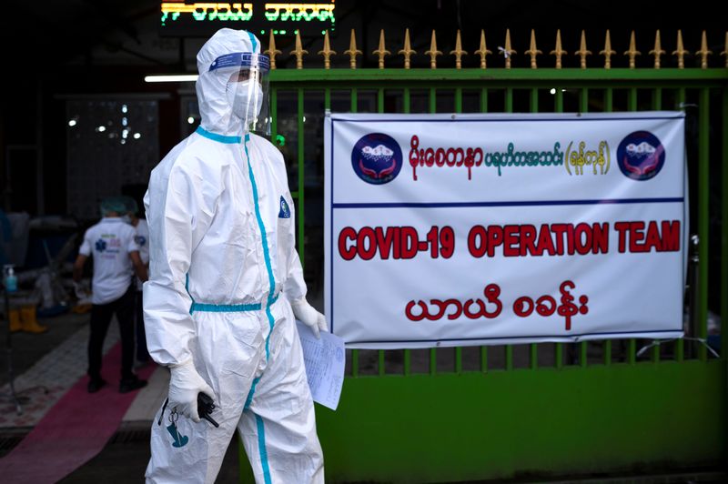A volunteer wearing a protective suit stands as he waits to transfer suspect cases to a quarantine center amid the outbreak of the coronavirus diseases in Yangon