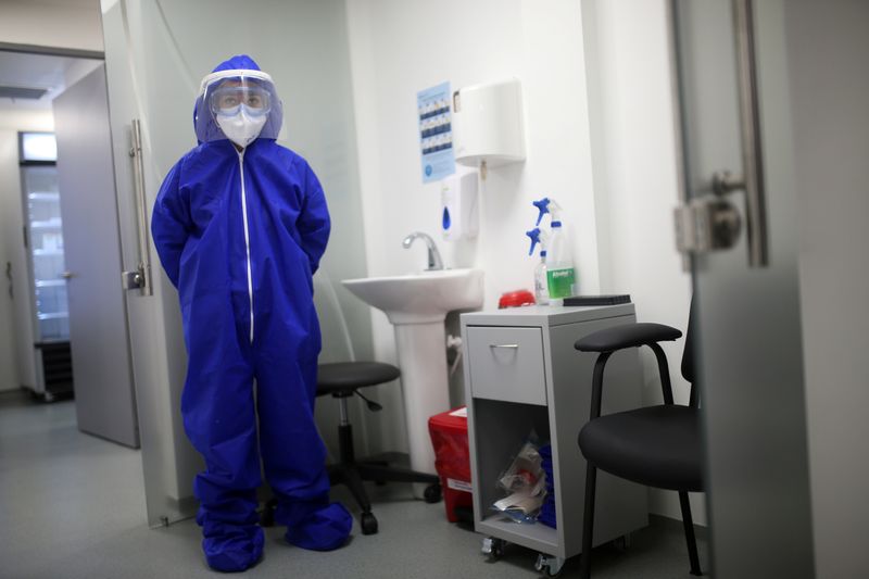 FILE PHOTO: A nurse wearing protective gear is seen inside a coronavirus disease (COVID-19) sampling room of the Synlab laboratory, at El Dorado airport in Bogota