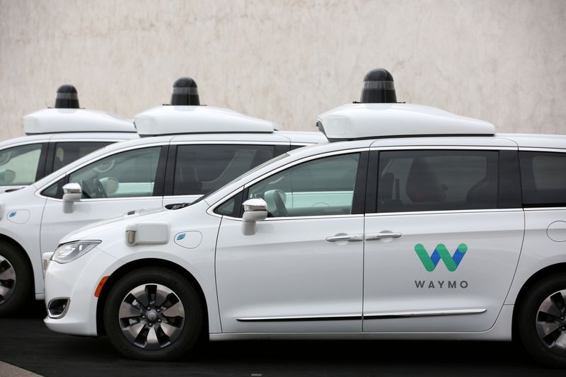 FILE PHOTO: Three of the fleet of 600 Waymo Chrysler Pacifica Hybrid self-driving vehicles are parked and diaplayed during a demonstration in Chandler, Arizona