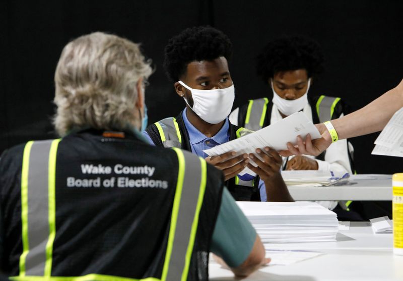 FILE PHOTO: FILE PHOTO: FILE PHOTO: FILE PHOTO: Poll workers prepare absentee ballots for the general election in Raleigh