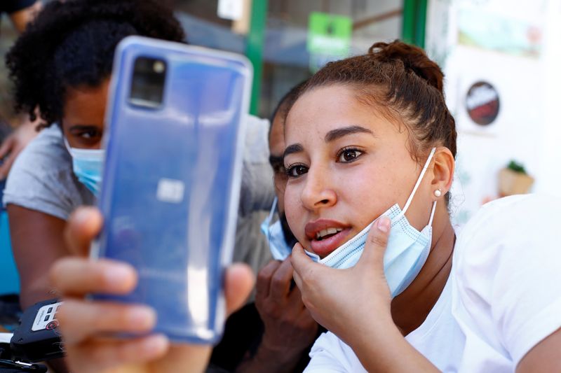 Sarah Bettache reacts during a video call with her brother Ahmed, a migrant from Morocco, in the port of Arguineguin