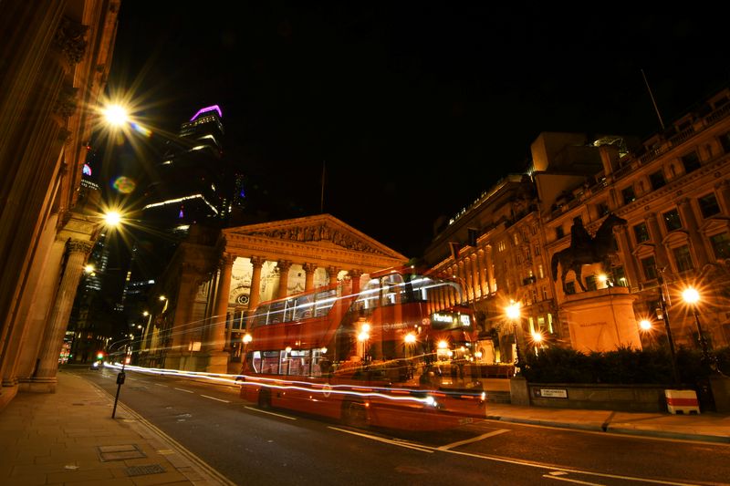 An empty bus is driven through the quiet streets outside the Bank of England in the early hours in London