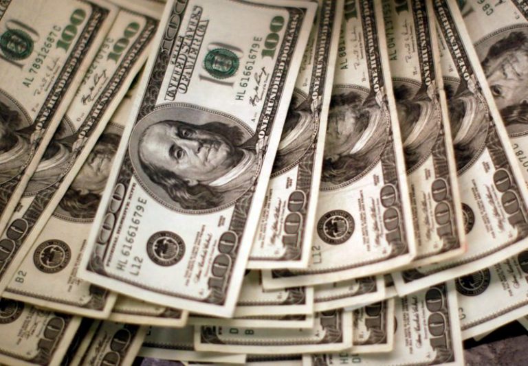 Dollar holds gains as investors adjust vaccine expectations