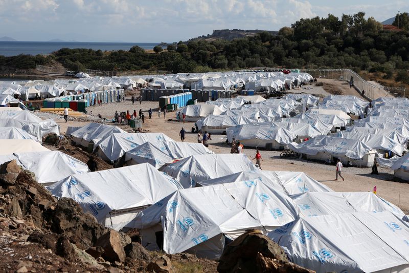 FILE PHOTO: Refugees and migrants make their way in the Kara Tepe camp on the island of Lesbos