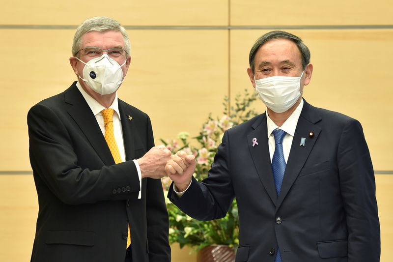 Japan's Prime Minister Yoshihide Suga greets International Olympic Committee (IOC) president Thomas Bach during their meeting in Tokyo