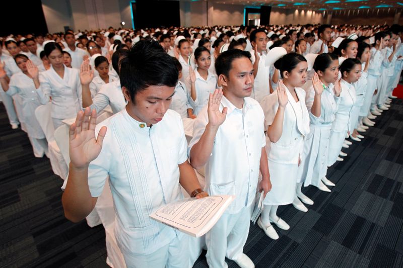 FILE PHOTO: Newly graduate nurses take their oath during an oath taking ceremony of professional nurses inside a mall in Manila