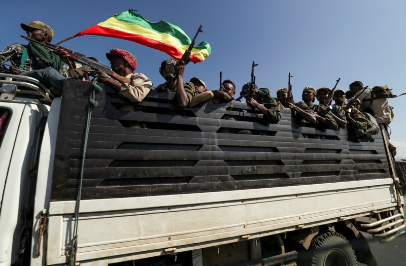 FILE PHOTO: Members of Amhara region militias ride on their truck as they head to face the Tigray People's Liberation Front in Sanja