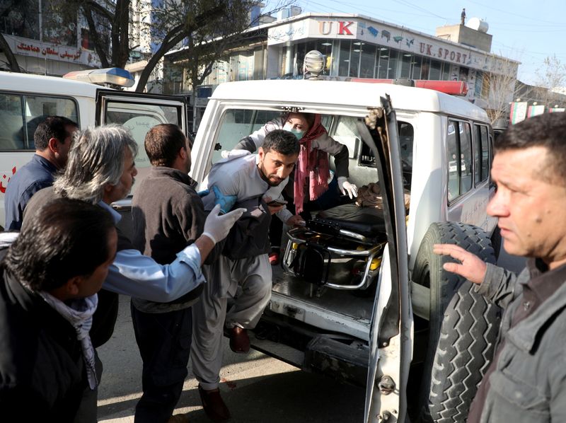 An injured man is carried to a hospital after rockets hit residential areas in Kabul