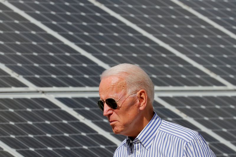FILE PHOTO: Joe Biden walks past solar panels in Plymouth, New Hampshire