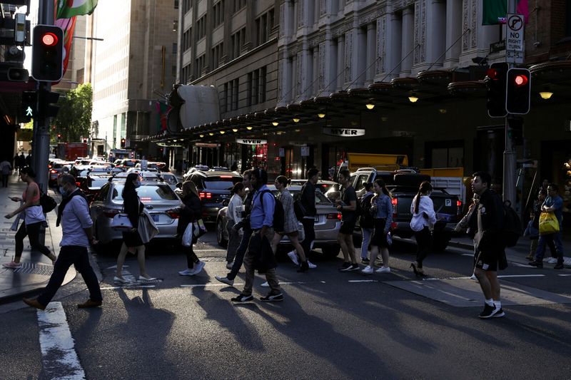 People walk through a congested intersection in the city centre of Sydney