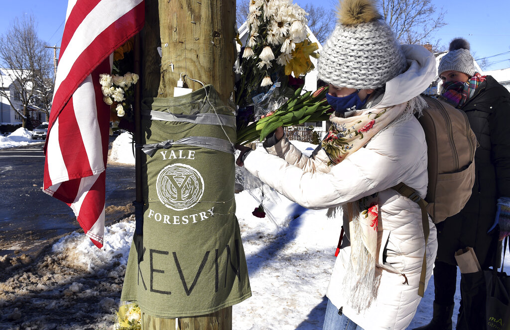 Yale postdoctoral students Maria Kochugaeva, left, and Elvira Mulyukova leave flowers at a memorial for Yale School of the Environment grad student Kevin Jiang at the corner of Lawrence and Nicoll Street in New Haven, Conn., Monday, Feb. 8, 202 near where Jiang was killed on Feb. 6, 2021. (Arnold Gold/Hearst Connecticut Media via AP)