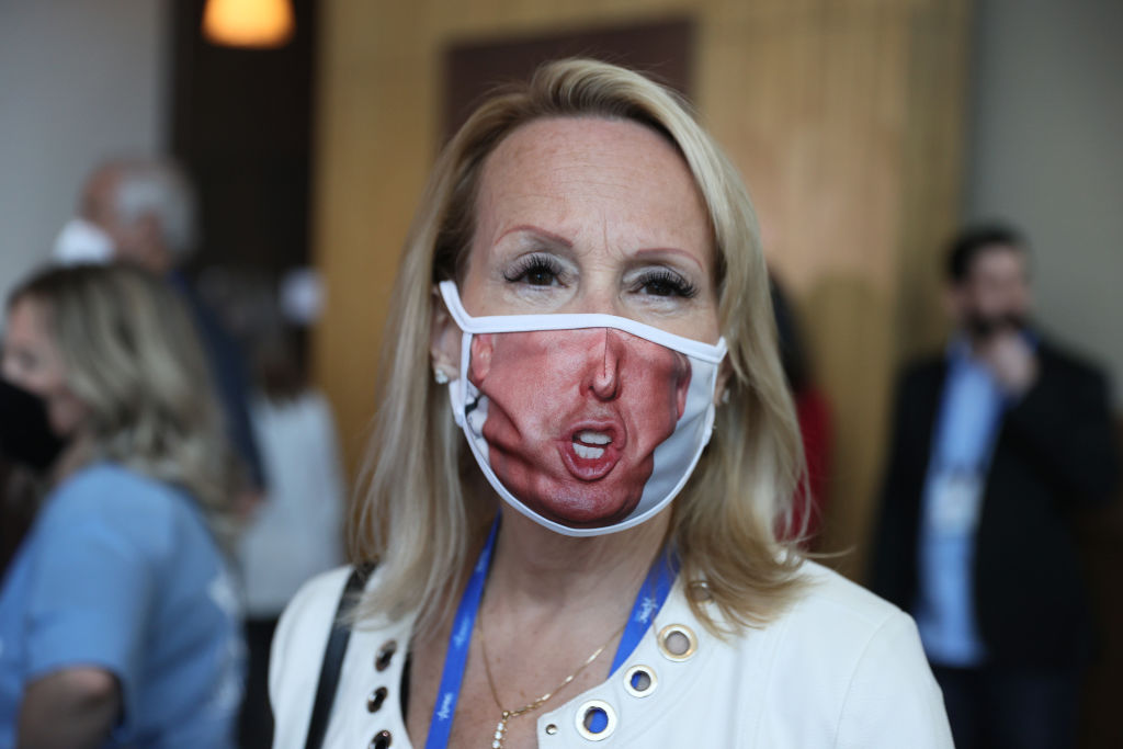 ORLANDO, FLORIDA - FEBRUARY 26: A visitor (who didn't want to provide her name) wears a face mask with a picture of former President Donald Trump on it during the Conservative Political Action Conference held in the Hyatt Regency on February 26, 2021 in Orlando, Florida. Begun in 1974, CPAC brings together conservative organizations, activists, and world leaders to discuss issues important to them. (Photo by Joe Raedle/Getty Images)