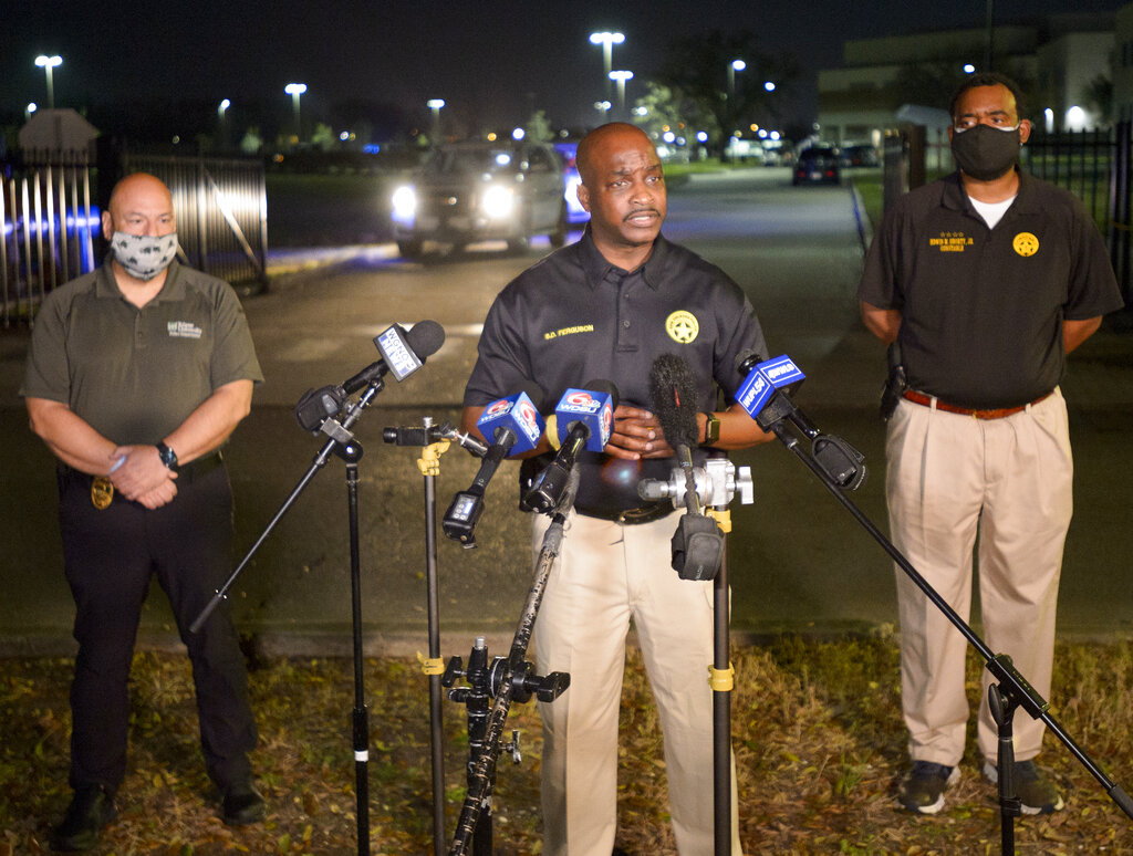 New Orleans Police Chief Shaun Ferguson, center, updates the media on the investigation of a shooting at George Washington Carver High School where a law enforcement officer was fatally shot as a basketball game was being played in New Orleans, Friday, Feb. 26, 2021. (Max Becherer/The Times-Picayune/The New Orleans Advocate via AP)