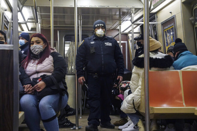 Police patrol the A line subway train bound to Inwood, after NYPD deployed an additional 500 officers into the subway system following deadly attacks, Saturday Feb. 13, 2021, in New York. Authorities say an unidentified man could be responsible for four separate stabbing attacks in the New York City subways that have left two people dead. New York police say the assaults happened between Friday morning and early Saturday. (AP Photo/Bebeto Matthews)