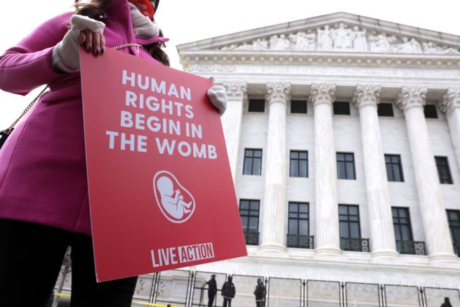 WASHINGTON, DC - JANUARY 29: A pro-life activist holds a sign outside the U.S. Supreme Court during the 48th annual March for Life January 29, 2021 in Washington, DC. Due to the COVID-19 pandemic, a much smaller group of activists participated in the annual march that marked the 1973 Roe v. Wade ruling by the U.S. Supreme Court that had legalized abortion. (Photo by Alex Wong/Getty Images)