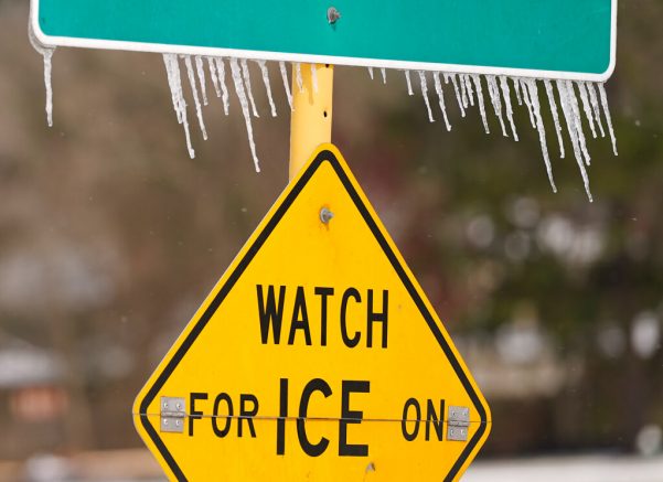 Icicles hang on a watch for ice on bridge road sign Monday, Feb. 15, 2021 in Houston. A winter storm making its way from the southern Plains to the Northeast is affecting air travel. (Melissa Phillip/Houston Chronicle via AP)