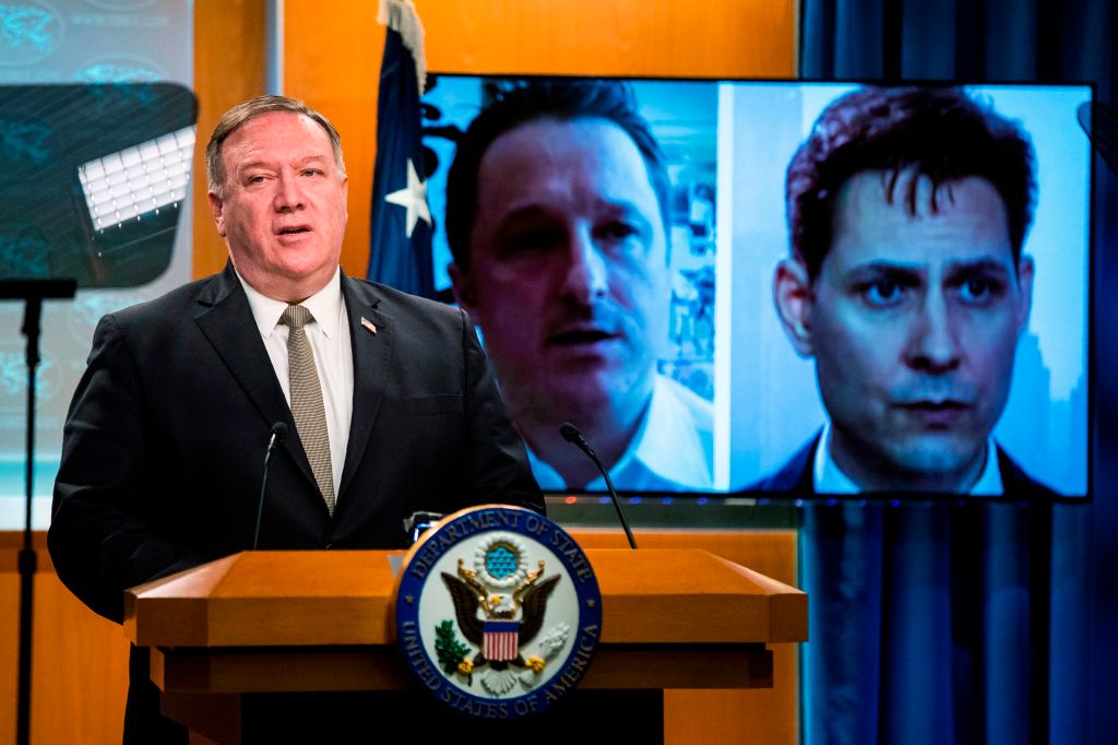  Michael Spavor, a Canadian businessman and Michael Kovrig, right, a former Canadian diplomat, detained in China since December 2018, are shown on a video monitor as US Secretary of State Mike Pompeo, speaks during a news conference at the State Department, Wednesday, July 1, 2020, in Washington. (Photo by Manuel Balce CENATA / POOL / AFP) (Photo by MANUEL BALCE CENATA/POOL/AFP via Getty Images)