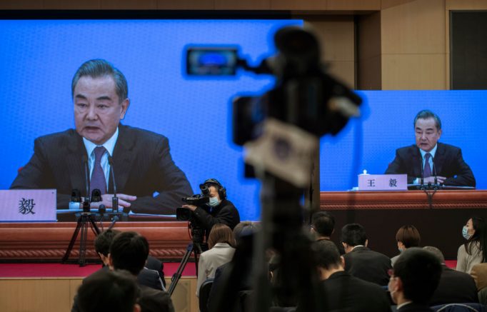 BEIJING, CHINA - MARCH 07: China's Foreign Minister Wang Yi, on screen, answers a question during a video news conference, held remotely as a precaution for COVID-19, as part of the National People's Congress on March 7, 2021 in Beijing, China.The annual political gatherings of the National Peoples Congress and the Chinese People's Political Consultative Conference, known as the Two Sessions, brings together Chinas leadership and lawmakers to set the blueprint for the coming year.  It is considered the most important event on the governments calendar and offers a rare glimpse at what President Xi Jinping and top officials see as priorities.  With the pandemic largely under control in China, discussions this year are expected to signal Beijings intentions around technology competition, control over Hong Kong, and strategic threats posed by Western countries including the United States. The political meetings, held at the Great Hall of the People at the edge of Tiananmen Square in central Beijing, can typically last for up to two weeks. (Photo by Kevin Frayer/Getty Images)