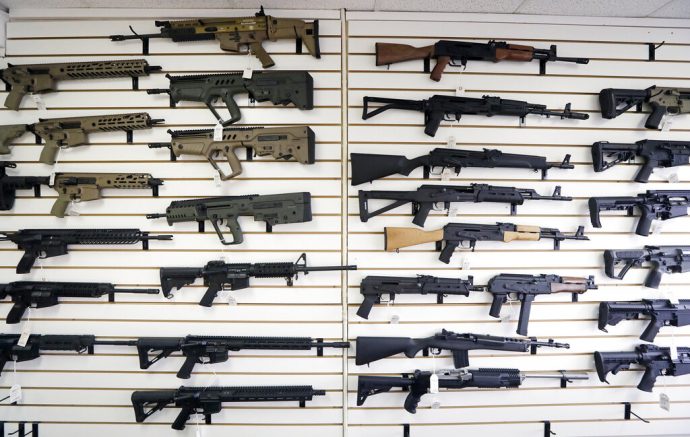 FILE - In this Oct. 2, 2018, file photo, semi-automatic rifles fill a wall at a gun shop in Lynnwood, Wash. Mass shootings in Georgia and Colorado in March 2021, that left several people dead, have reignited calls from gun control advocates for tighter restrictions on buying firearms and ammunition. But with Democrats in control of the federal government, gun rights advocates have been persuading Republican-run state legislatures to go the other way, making it easier to obtain and carry guns.(AP Photo/Elaine Thompson, File)