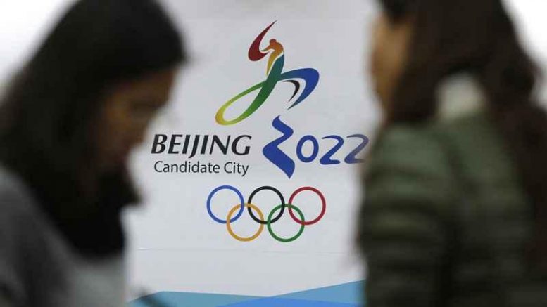 In this Nov. 4, 2014, file photo, journalists chat near the Beijing's bid for the 2022 Winter Olympics logo after attending a media briefing at the Beijing Olympics Headquarters in Beijing, China. A coalition of human-rights groups has met with the International Olympic Committee over calls to pull the 2022 Winter Olympics out of Beijing. (AP Photo / Andy Wong)