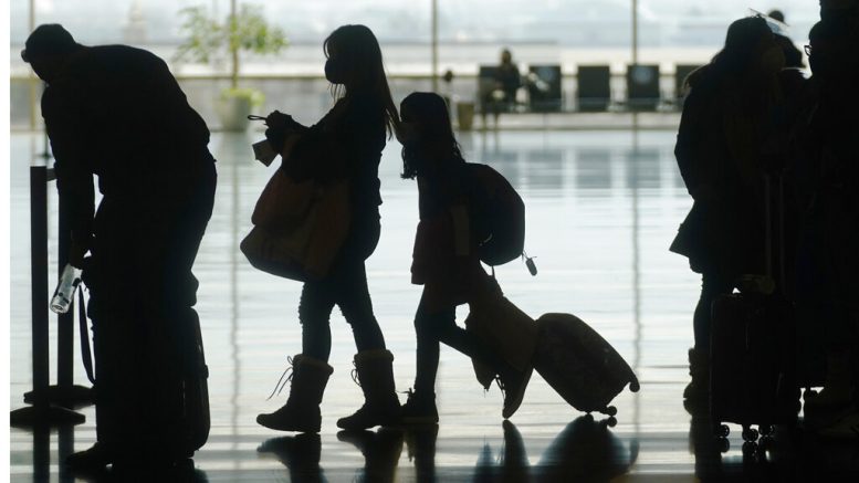 Travelers walk through the Salt Lake City International Airport Wednesday, March 17, 2021, in Salt Lake City. Airlines and others in the travel industry are throwing their support behind vaccine passports to boost pandemic-depressed travel, and authorities in Europe could embrace the idea quickly enough for the peak summer vacation season. (AP Photo/Rick Bowmer)