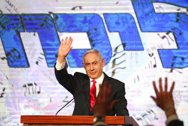 FILE - In this Wednesday, March. 24, 2021 file photo, Israeli Prime Minister Benjamin Netanyahu waves to his supporters after the first exit poll results for the Israeli parliamentary elections at his Likud party's headquarters in Jerusalem. After a hard-fought election, an Arab Islamist, Mansour Abbas, leader of the United Arab List, also known by the Hebrew name Ra'am, could choose Israel’s next prime minister. Tuesday’s elections have left a razor-thin margin between a right-wing coalition led by Netanyahu and a diverse array of parties bent on ousting him. Each side needs the support of Ra'am. (AP Photo/Ariel Schalit, `file)