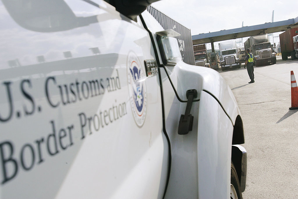 Miami, UNITED STATES: An agent from the US Customs and Border Protection section of the US Homeland Security Department watches trailer trucks waiting to leave the Port of Miami at a check point serviced by a Mobile Radiation Portal Monitor (MRPM) 06 December 2006. The check-point is one many measures implemented by local and federal authorities throughout various ports in the US in an effort to maintain vigilance against possible terrorist threats to the US. AFP PHOTO/Roberto SCHMIDT (Photo credit should read ROBERTO SCHMIDT/AFP via Getty Images)