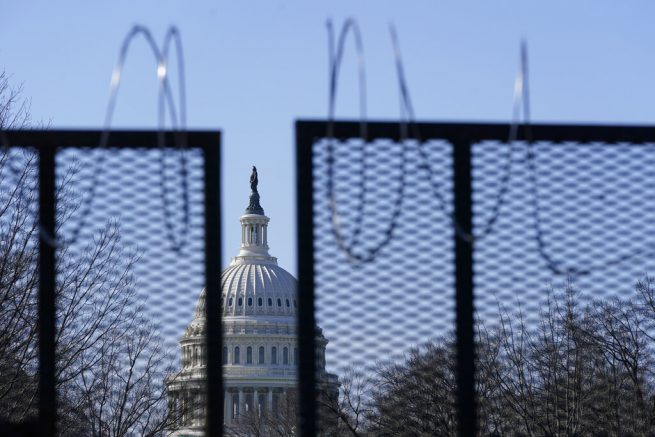 FILE - In this March 20, 2021, file photo the U.S. Capitol dome stands past partially-removed razor wire hanging from a security fence on Capitol Hill in Washington. Authorities suggested for weeks in court hearings and papers that members of the Oath Keepers militia group planned their attack on the Capitol in advance in an effort to block the peaceful transition of power. But prosecutors have since said it’s not clear whether the group was targeting the Capitol before Jan. 6, giving defense attorneys an opening to try to sow doubt in the government’s case. (AP Photo/Patrick Semansky, File)