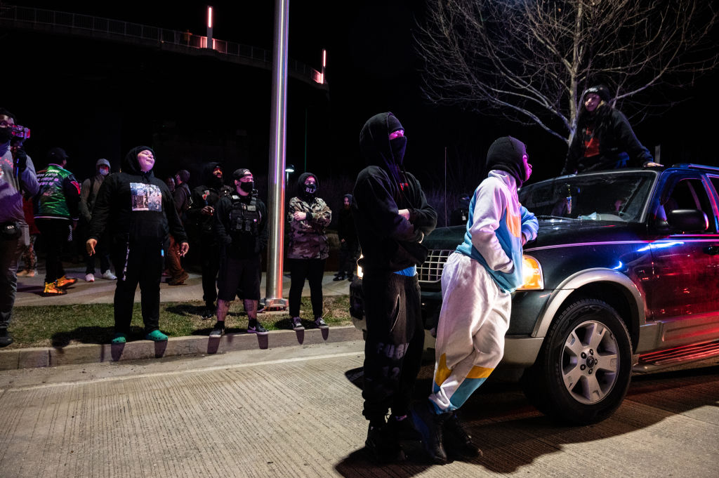 LOUISVILLE, KY - MARCH 13: A group of protesters are illuminated by emergency lights from Louisville Metro Police Department vehicles after the Breonna Taylor memorial events on March 13, 2021 in Louisville, Kentucky. Today marks the one year anniversary since Taylor was killed in her apartment during a botched no-knock raid executed by LMPD. (Photo by Jon Cherry/Getty Images)