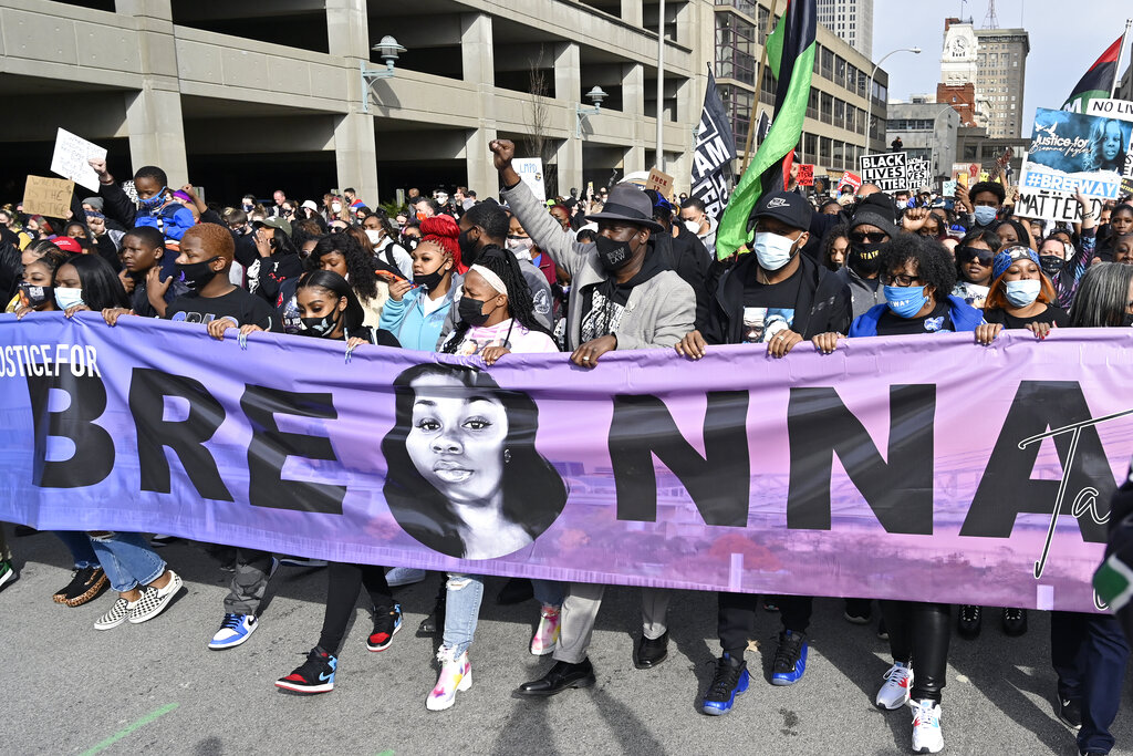 Tamika Palmer, center, the mother of Breonna Taylor, leads a march through the streets of downtown Louisville on the one year anniversary of her death in Louisville, Ky., Saturday, March 13, 2021. To her right is attorney Ben Crump. (AP Photo/Timothy D. Easley)