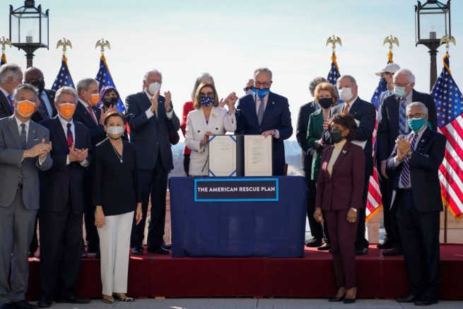 WASHINGTON, DC - MARCH 10: Surrounded by Democratic House and Senate Committee Chairs, Speaker of the House Nancy Pelosi (D-CA) and Senate Majority Leader Chuck Schumer (D-NY) pose for photos after signing the $1.9 trillion COVID-19 relief bill during a bill enrollment ceremony on the West Front of the U.S. Capitol on March 10, 2021 in Washington, DC. President Joe Biden aims to sign the legislation in time to meet a Sunday deadline to renew unemployment aid programs. (Photo by Drew Angerer/Getty Images)