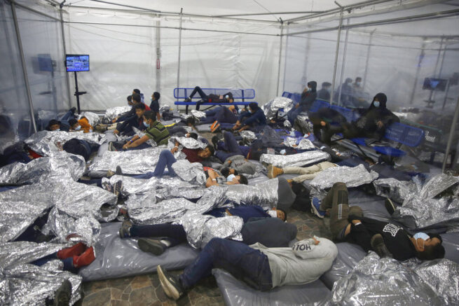 Young children rest inside a pod at the U.S. Customs and Border Protection facility, the main detention center for unaccompanied children in the Rio Grande Valley, in Donna, Texas, Tuesday, March 30, 2021. The children are housed by the hundreds in eight pods that are about 3,200 square feet in size. Many of the pods had more than 500 children in them. The Biden administration for the first time allowed journalists inside its main detention facility at the border for migrant children, revealing a severely overcrowded tent structure where more than 4,000 kids and families were crammed into pods and the youngest kept in a large play pen with mats on the floor for sleeping. (AP Photo/Dario Lopez-Mills, Pool)