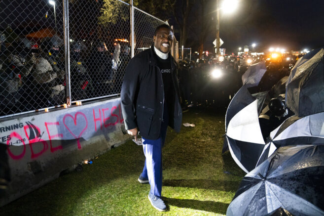 Michael Odiari argues with demonstrators to stop attempting to agitate authorities by advancing on a perimeter security fence during a protest decrying the shooting death of Daunte Wright outside the Brooklyn Center Police Department, Wednesday, April 14, 2021, in Brooklyn Center, Minn. (AP Photo/John Minchillo)