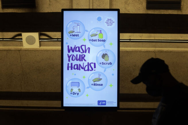 WASHINGTON, DC - APRIL 07: A CDC hand washing guideline is seen on a screen as a passenger passes by at Metro Center Station April 7, 2020 in Washington, DC. Washington Metropolitan Area Transit Authority announced that it is cutting late night service and closing all Metro stations at 9pm daily until further notice. (Photo by Alex Wong/Getty Images)