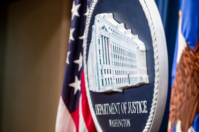 WASHINGTON, DC - DECEMBER 05: The U.S. Department of Justice seal on the stage where U.S. and U.K. Law enforcement officials will announce warrants for the arrests of Maksim Viktorovich Yakubets and Igor Olegovich Turashev, two Russian hackers associated with a group called Evil Corp., at the U.S. Department of Justice on December 5, 2019 in Washington, DC. Today the U.S. Department of Justice, Federal Bureau of Investigations (FBI), and the U.S. Treasury Departments Office of Foreign Assets Control (OFAC) took action against Evil Corp, the Russia-based cybercriminal organization responsible for the development and distribution of the Dridex malware. (Photo by Samuel Corum/Getty Images)