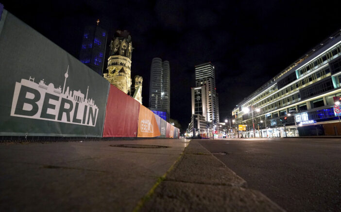 The deserted 'Budapesater Strasse' (Budapest Road) at the bottom of the Kaiser Wilhelm Memorial Church, left, is pictured during a nationwide curfew in Berlin, Germany, Saturday, April 24, 2021. To reduce the number of coronavirus infections, people in Germany are not allowed to be outdoors between ten o'clock in the night and five o'clock in the morning. (AP Photo/Michael Sohn)