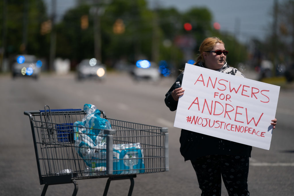 ELIZABETH CITY, NC - APRIL 23: Robin Woodard holds a sign while blocking an intersection during a protest march April 23, 2021 in Elizabeth City, North Carolina. Protestors were calling for the release of body camera footage from the shooting death of Andrew Brown Jr. on April 21. (Photo by Sean Rayford/Getty Images)