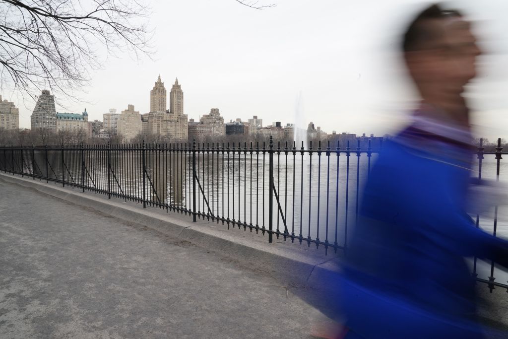 With the iconic Eldorado Apartments in the background a man jogs around the Jacqueline Kennedy Onassis Reservoir in Central Park March 16, 2021 in New York. (Photo by TIMOTHY A. CLARY / AFP) (Photo by TIMOTHY A. CLARY/AFP via Getty Images)