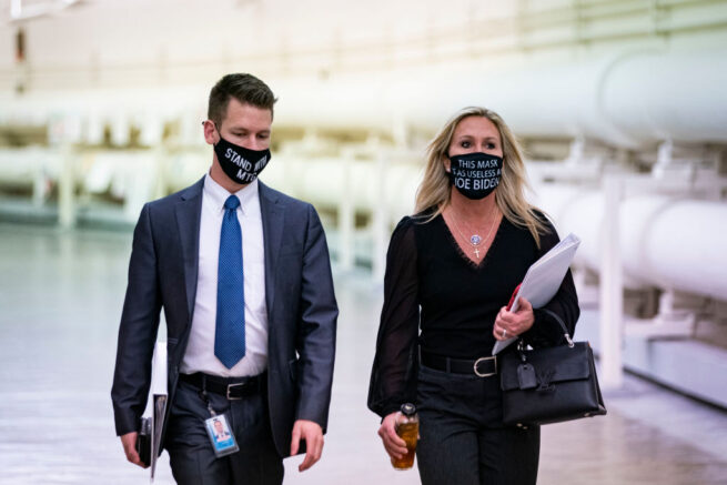WASHINGTON, DC - FEBRUARY 25: Rep. Marjorie Taylor Greene (R-GA) wears a protective mask bearing the words "This mask is as useless as Joe Biden," as she walks with an aide to a vote in the Cannon Tunnell on Capitol Hill, on February 25, 2021 in Washington, DC. (Photo by Al Drago/Getty Images)