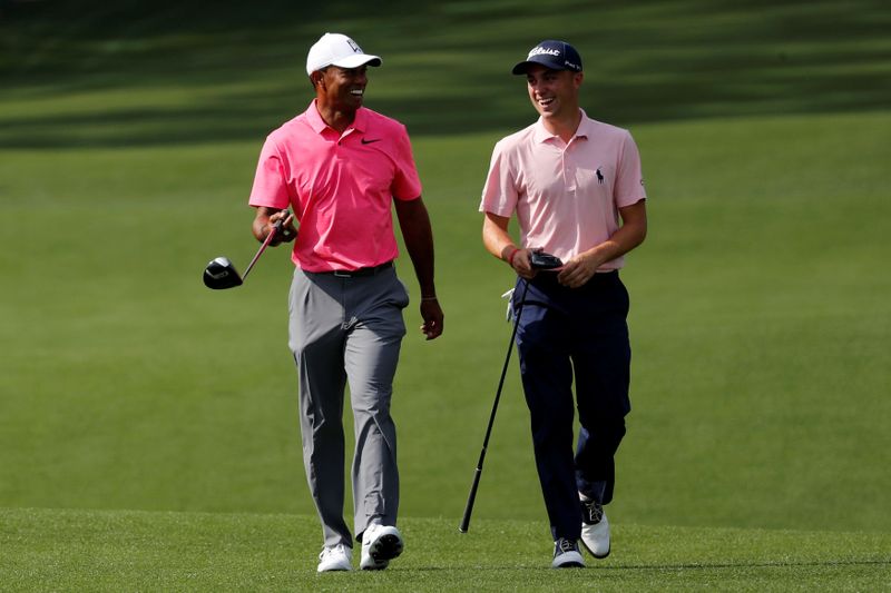 FILE PHOTO: Woods of the U.S. shares a laugh with compatriot Thomas during practice for the 2018 Masters golf tournament in Augusta