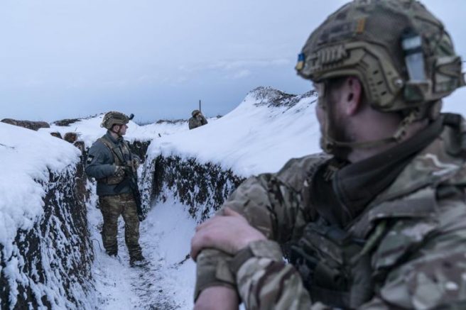Ukrainian servicemen walk along a snow covered trench guarding their position at the frontline near Vodiane, about 750 kilometers (468 miles) south-east of Kyiv, eastern Ukraine, Saturday, March 5, 2021. The country designated 14,000 doses of its first vaccine shipment for the military, especially those fighting Russia-backed separatists in the east. Ukrainians are becoming increasingly opposed to vaccination: an opinion poll this month by the Kyiv International Institute of Sociology found 60% of the country's people don't want to get vaccinated, up from 40% a month earlier. (AP Photo/Evgeniy Maloletka)