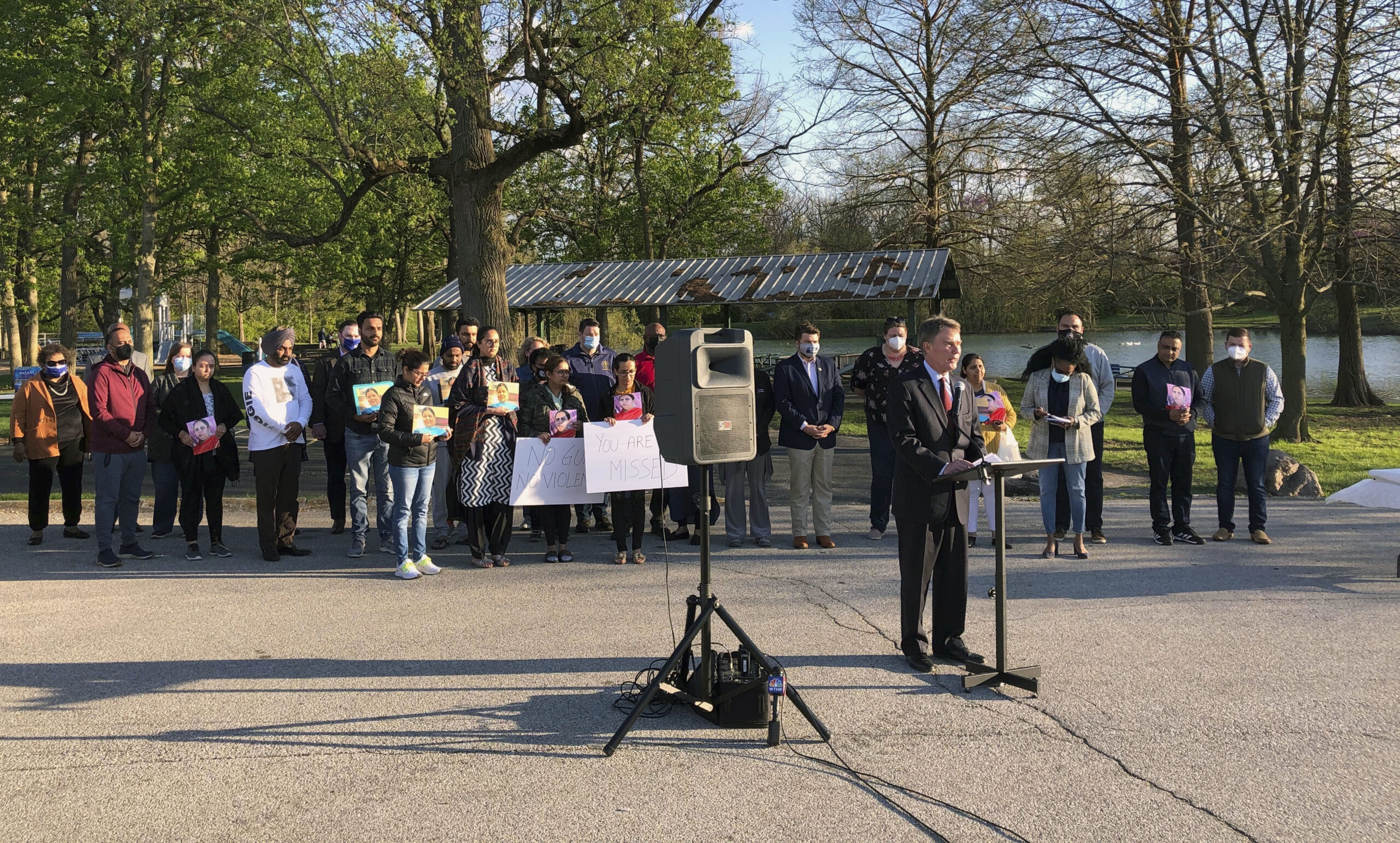 Indianapolis Mayor Joe Hogarth speaks at a vigil Saturday, April 17, 2021 at Krannert Park on Indianapolis’ west side to memorialize the eight people killed in the mass shooting at a FedEx warehouse. Behind him, members of the Sikh community, whose loved ones were killed, hold signs demanding policymakers make gun law reforms in the wake of the shooting. (AP Photo/Casey Smith)