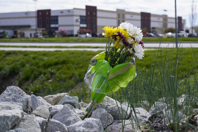 A single bouquet of flower sits in the rocks across the street from the FedEx facility in Indianapolis, Saturday, April 17, 2021 where eight people were shot and killed. A gunman killed eight people and wounded several others before apparently taking his own life in a late-night attack at a FedEx facility near the Indianapolis airport, police said, in the latest in a spate of mass shootings in the United States after a relative lull during the pandemic. (AP Photo/Michael Conroy)
